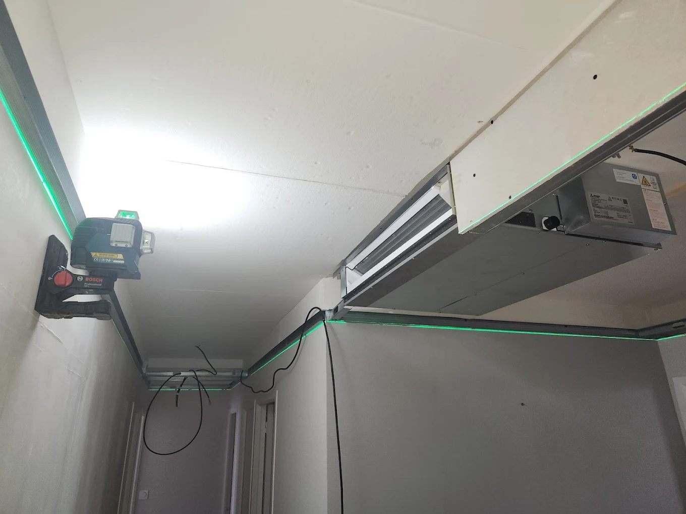 Unité de climatisation gainable en cours d’intégration dans un faux plafond